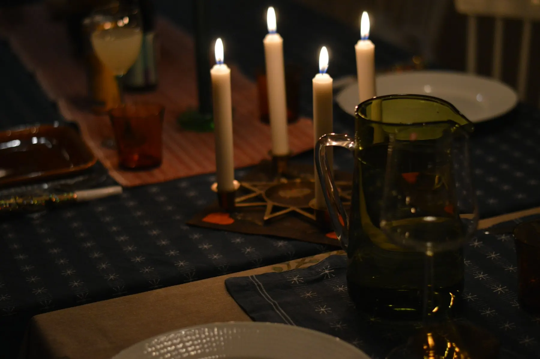 Candles lit on a dinner table at night